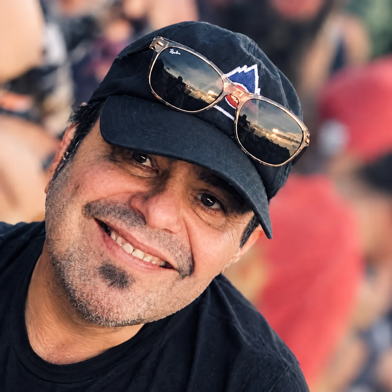 Rob, who makes Tamale Board, photographed outdoors with a crowd softly blurred behind him.