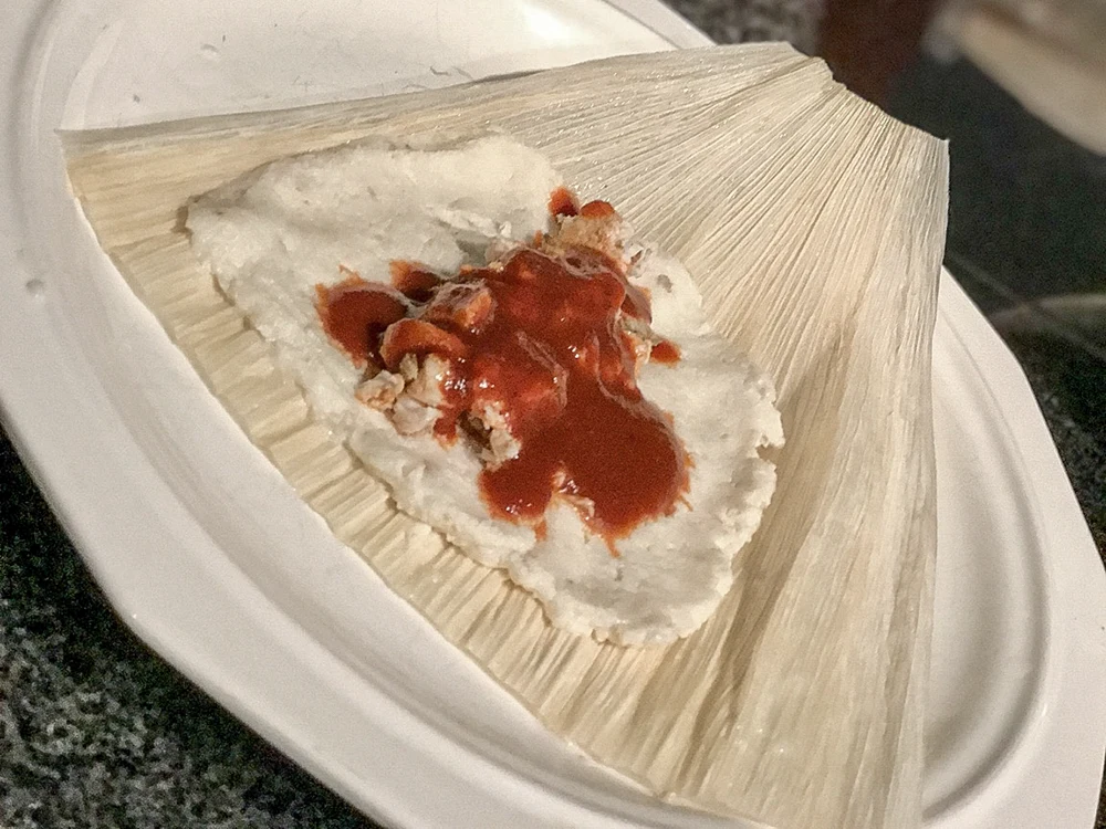 Masa and filling on an open corn husk.